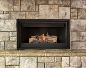 A closeup of a home's fireplace gas insert. You can see the brick surrounding the fireplace as well.
