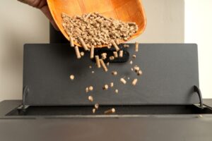 A closeup of wood pellets being poured into a pellet stove